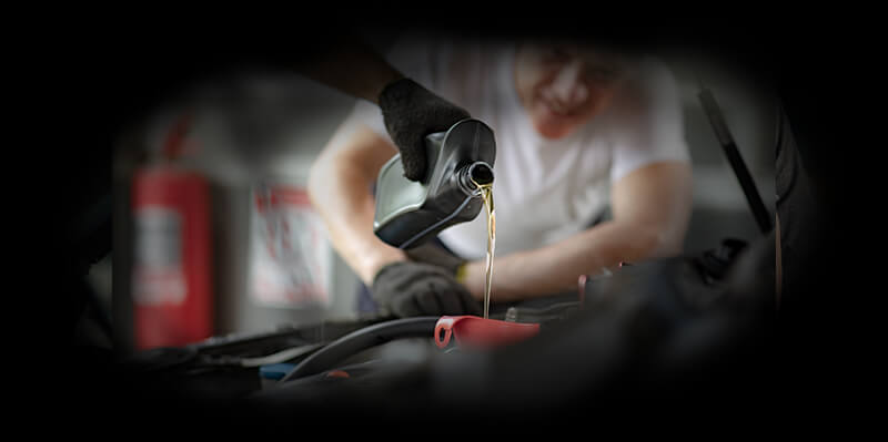 Mann füllt Motoröl nach seinem Auto nach