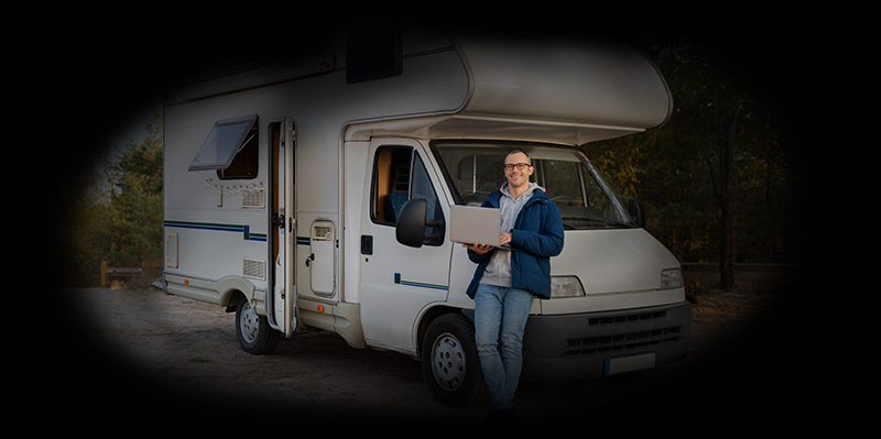 Zufriedener Mann vor dem Wohnmobil vor der Urlaubsreise – bereit für den Start nach erfolgreichem Frühjahrscheck